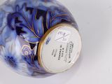 a blue and white vase with a gold decoration on it