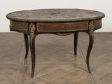 une petite table avec un plateau en marbre sur un plancher en bois