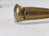 a gold spoon sitting on a table with a white background