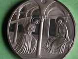 an image of a silver medal with a woman kneeling in front of a man