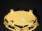 a yellow plate with a bird on it on a black surface