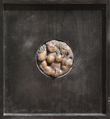 un gros plan sur une plaque métallique représentant une femme tenant un enfant dans ses bras