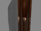 a tall wooden clock that is on display on the wall