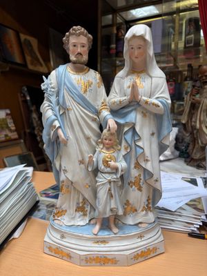 une statue représentant un homme et une femme tenant un enfant dans leurs bras