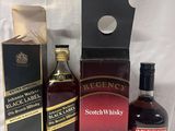 three bottles of whisky and a box of liquor sitting on a table