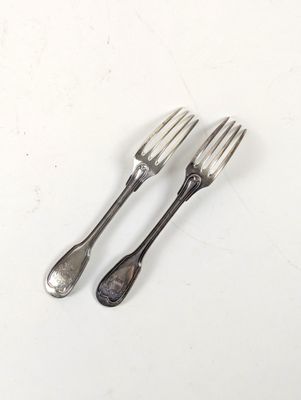 deux fourchettes et deux cuillères posées sur une surface blanche