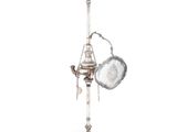 une lampe ancienne en argent plaqué, avec une casserole et une poêle posées sur un socle