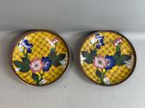 deux fleurs jaunes et bleues sont posées sur une surface blanche