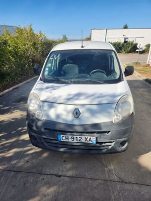 la petite camionnette blanche est garée sur le bord de la route