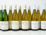 six bouteilles de vin sont alignées sur une table