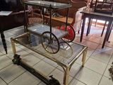 une table sur laquelle repose une étagère en verre, dans une pièce