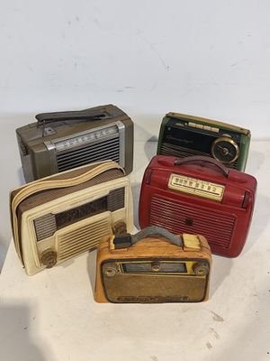 Trois radios à l'ancienne sont posées sur une surface blanche