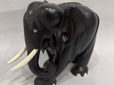 statue of an elephant with tusks and tusks on a white background