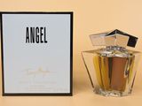 an angel perfume bottle next to a box on a table