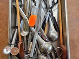 un évier en métal rempli de divers ustensiles de cuisine