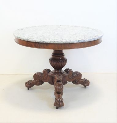 une table avec un plateau en marbre posée sur un piédestal