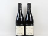 deux bouteilles de vin posées l'une à côté de l'autre sur une surface blanche