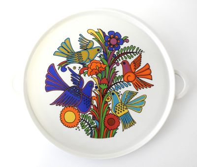 une assiette blanche décorée d'oiseaux et de fleurs colorés