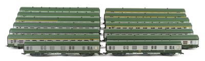 several green and white train cars sitting next to each other on a white surface