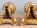 two gold colored candlesticks on a wooden table