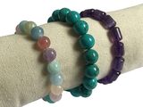 deux bracelets composés de perles de différentes couleurs posés sur une serviette blanche