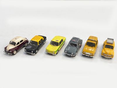 plusieurs petites voitures sont alignées sur une surface blanche