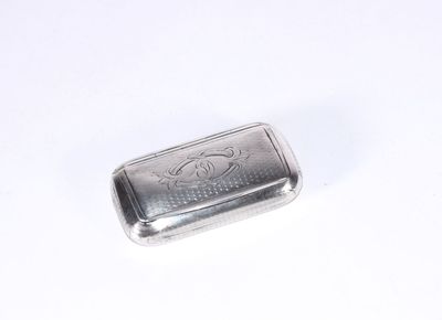 un petit objet argenté sur une surface blanche