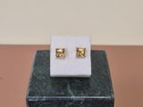 a close up of a pair of earrings sitting on top of a marble block