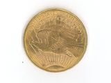 a close up of a gold coin on a white surface