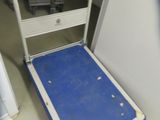a blue and white luggage cart sitting in the corner of a room