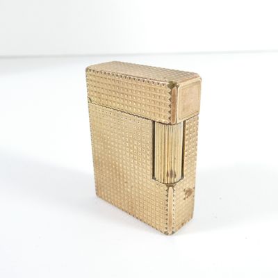 a gold colored lighter sitting on a white surface