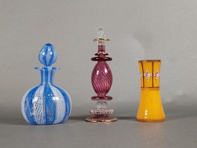 trois vases en verre de couleurs différentes posés sur une table