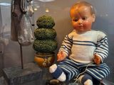 a baby doll sitting on a glass shelf in a display case