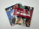 trois livres posés sur une surface blanche, sur lesquels figurent des photos de personnes