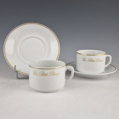 a white cup and saucer with gold trim and saucer