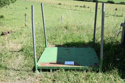 a green platform in the middle of a grassy field