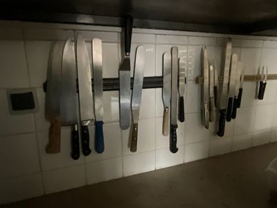 de nombreux couteaux accrochés au mur de la cuisine