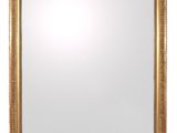 un miroir encadré d'or sur un mur blanc avec un fond blanc