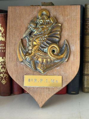 a plaque on a shelf with books on it