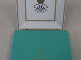 an open box with a gold crown on it sitting on a white surface