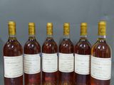 six bouteilles de vin sont alignées sur une table