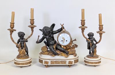 trois bougies et une horloge posées sur une table
