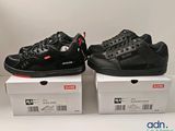 two pairs of black and red sneakers are on top of boxes