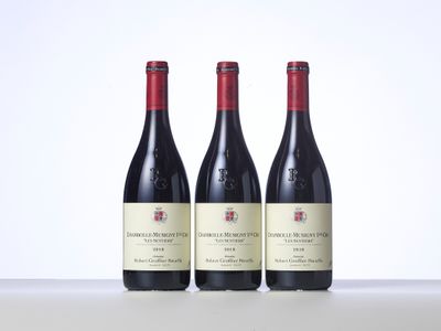 trois bouteilles de vin posées sur une table l'une à côté de l'autre