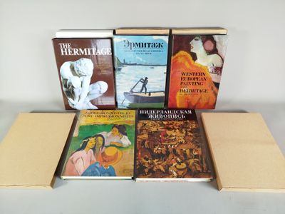 plusieurs livres posés sur une boîte en carton, elle-même posée sur une table