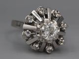 an old cut diamond ring with a center stone surrounded by small diamonds