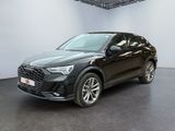 une Audi QX noire garée dans une grande pièce