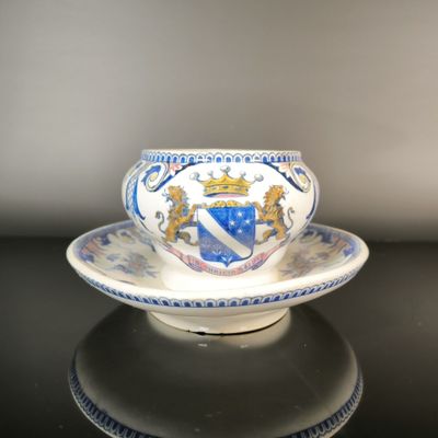 a cup and saucer with a coat of arms on it
