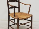 une chaise en bois avec une assise en bois posée sur un sol blanc