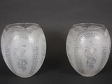 une paire de vases blancs ornés de motifs sur fond noir